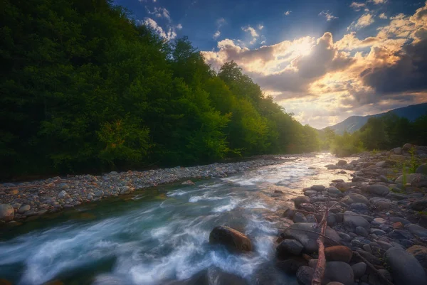 速い流れる山の川の上に美しい夕日 — ストック写真