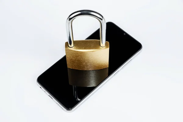 金色的挂锁躺在一个白色背景隔离的智能手机上 电话数据保护的概念 — 图库照片
