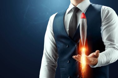 İş adamının avucunda havalanan bir roketi var. Girişim konsepti, kâr artışı, ölçekleme. Karışık ortam