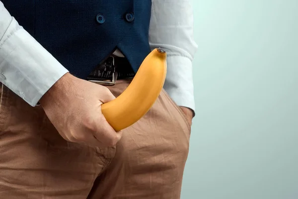 男の手はフライ クローズアップの背景にバナナを保持しています 潜在的な概念 影響力 男性の強さ 効力を向上させるために錠剤 コピースペース — ストック写真