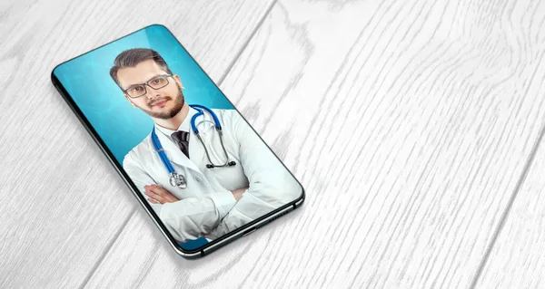 Portrait of a man, a doctor on a smartphone screen, a video conference, an appointment with a doctor online. Medical technology concept, the future of medicine. Mixed media