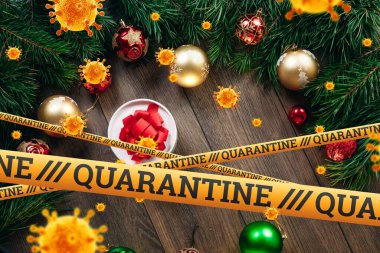 Kendini izole etme, evde tatil, üzerinde karantina ve uçan virüsler yazan sarı bir kurdelenin altında Noel arkaplanı. salgın, covid-19