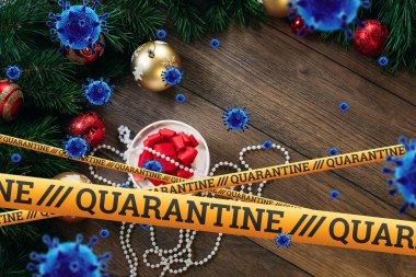 Kendini izole etme, evde tatil, üzerinde karantina ve uçan virüsler yazan sarı bir kurdelenin altında Noel arkaplanı. salgın, covid-19