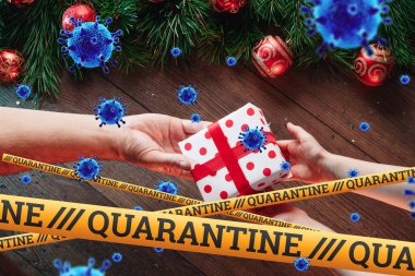 Kendini izole etme, evde tatil, üzerinde karantina ve uçan virüsler yazan sarı bir kurdelenin altında Noel arkaplanı. salgın, covid-19