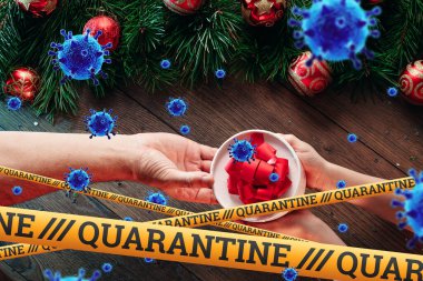 Kendini izole etme, evde tatil, üzerinde karantina ve uçan virüsler yazan sarı bir kurdelenin altında Noel arkaplanı. salgın, covid-19