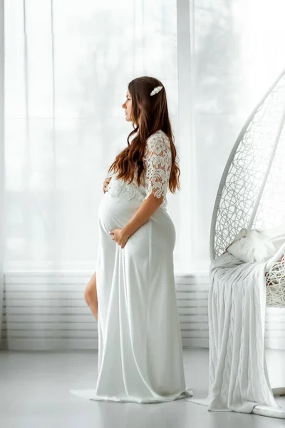 Uma Menina Grávida Roupas Brancas Fica Fundo Claro Bela Barriga — Fotografia de Stock