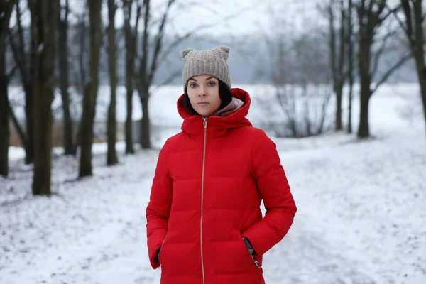 冬天的森林里 站着一个穿着红色长绒棉衣的小女孩 — 图库照片