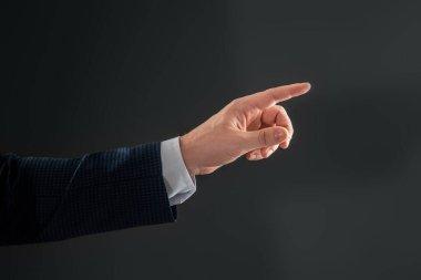 Takım elbiseli erkek, gri arka planda işaret parmağı hareketi gösteriyor. Navigator konsepti, baş, yakın plan