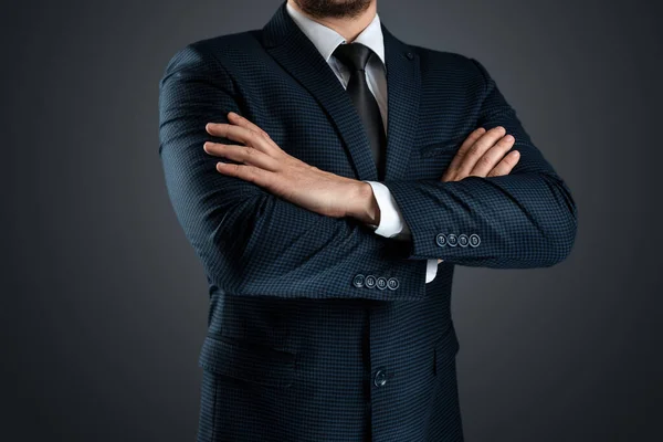 一个穿着西装的男人站在那里 胳膊交叉在灰色的背景上 概念商人 商业沟通 后续行动 — 图库照片