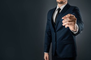 Takım elbiseli bir adam tükenmez kalemle elini uzatıyor, havada yazıyor. İş konsepti stoku. Yakın plan, kopyalama alanı