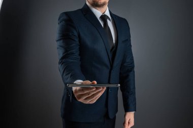 Takım elbiseli bir işadamı akıllı telefonu elinde tutuyor. Çevrimiçi iş konsepti, ağ oluşturma, serbest çalışma