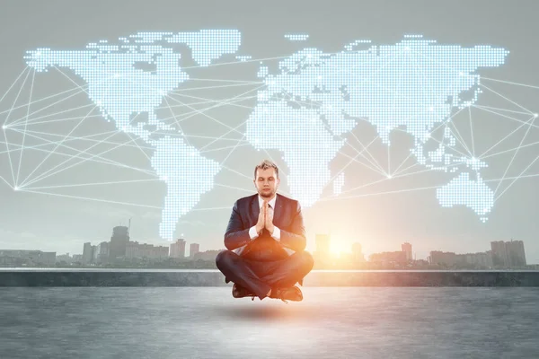 A man in a business suit, a businessman flies in the lotus position against the background of the world map. Concept for international business, global development, online sales