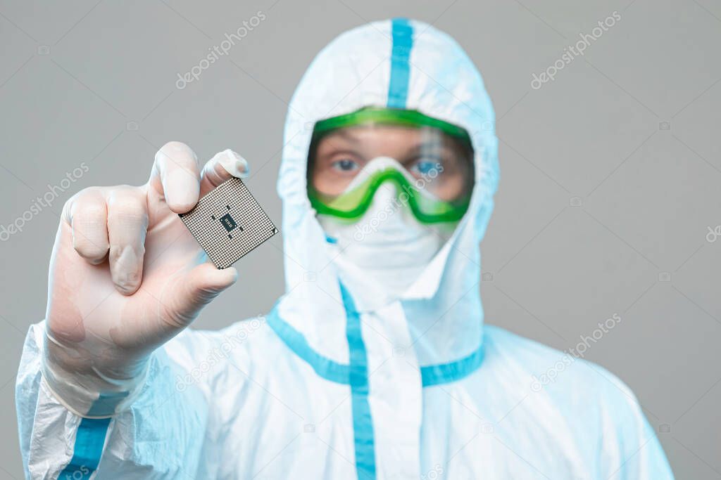 A man in sterile form holds a microprocessor in his hands, close-up. Microchip Design Technology, Advanced Manufacturing, Special Chip, Technologically Advanced Factory. Selective focus