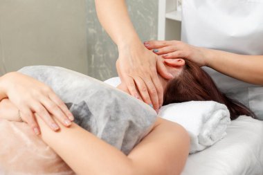 Boyun masajı yakın plan. Spa prosedürlerinde genç ve güzel bir kız. Vücut bakımı, oryantal masaj tedavileri, duruş düzeltmesi, güzellik tedavileri.
