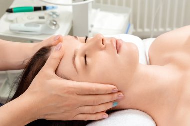 Güzel bir kızın yüzüne masaj yapılıyor, yakın plan çekimde. Cilt bakımı, güzellik uzmanı, kaplıca tedavisi, yüz hijyeni.