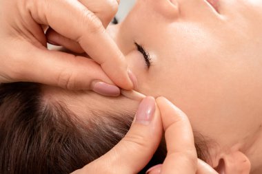 Güzel bir kızın yüzüne masaj yapılıyor, yakın plan çekimde. Cilt bakımı, güzellik uzmanı, kaplıca tedavisi, yüz hijyeni.