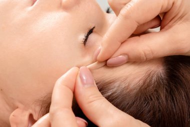 Güzel bir kızın yüzüne masaj yapılıyor, yakın plan çekimde. Cilt bakımı, güzellik uzmanı, kaplıca tedavisi, yüz hijyeni.