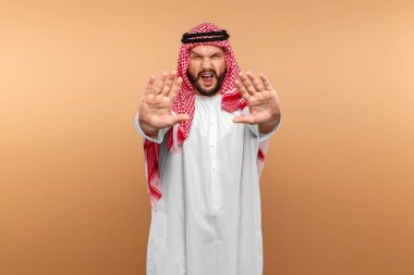 Ulusal giysili bir Arap 'ın elinde dur işareti var. Dishdasha, kandora, thobe, koronovirüs, bulaşıcı hastalıklara karşı koruma. Boşluğu kopyala