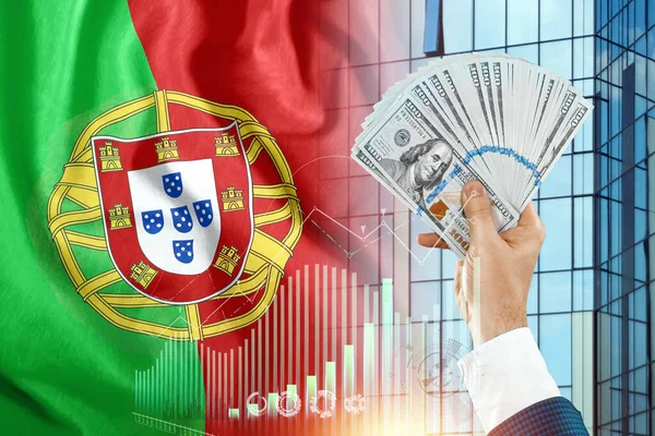 Money in a man's hand against the background of the flag of Portugal. Portuguese income. The financial condition of the inhabitants of Portugal, taxes, loans, mortgages. State debt of the country