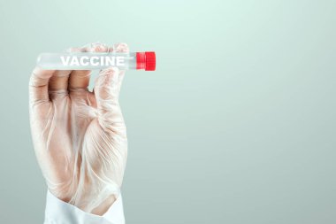 Eldivenli bir doktorun elinde COVID-19 aşısı olan bir test tüpü var. Tıbbi araştırma, yakın plan.