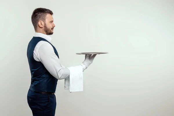 一个穿着白衬衫的男服务员站在旁边 手里拿着一个银盘 餐厅服务顾客的概念 — 图库照片