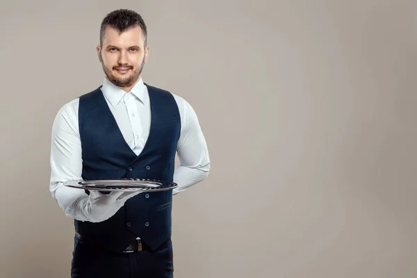 英俊的男服务员 白衬衫 拿着一个银盘 手放在背后 餐厅服务员为顾客服务的概念 — 图库照片