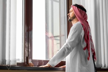 Bir Arap, bir işadamı, bir şeyh bir gökdelenin önünde duruyor. Yatırımlar, iş, internet üzerinden çalışma, çevrimiçi sözleşmeler