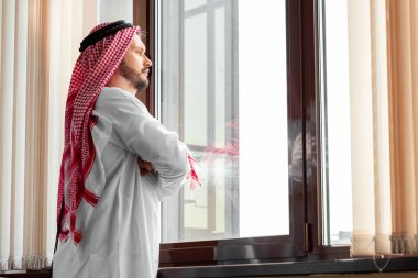 Bir Arap, bir işadamı, bir şeyh bir gökdelenin önünde duruyor. Yatırımlar, iş, internet üzerinden çalışma, çevrimiçi sözleşmeler