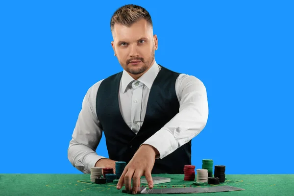 桌旁赌场的男尸蹲在蓝色背景下被隔离了 赌场概念 绿色赌场桌上的薯片 — 图库照片