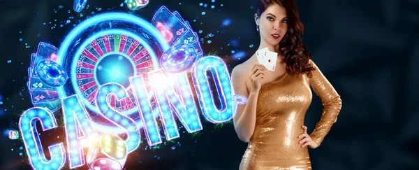 A beautiful young girl in a gold dress holds playing cards, neon casino inscription, cards and dice in her hands. Banner concept for casino, poker, flyer, gambling, croupier, header for the site