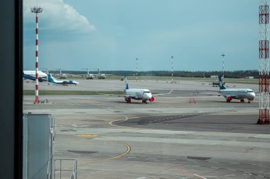 MINSK, BELARUS - 16 Haziran 2021 Minsk Uluslararası Havaalanı. Pencereden podyuma ve uçaklara kadar olan manzara azaldı. Uluslararası yolcu taşımacılığı