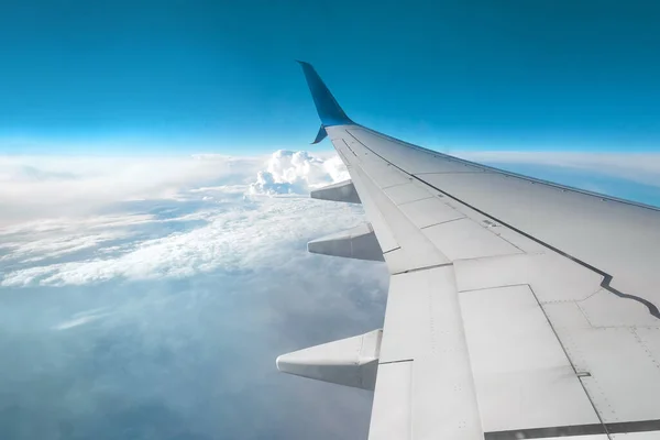 View from the window of a passenger plane above the clouds. International cargo transportation, air travel, transport, air travel, vacations. Copy space