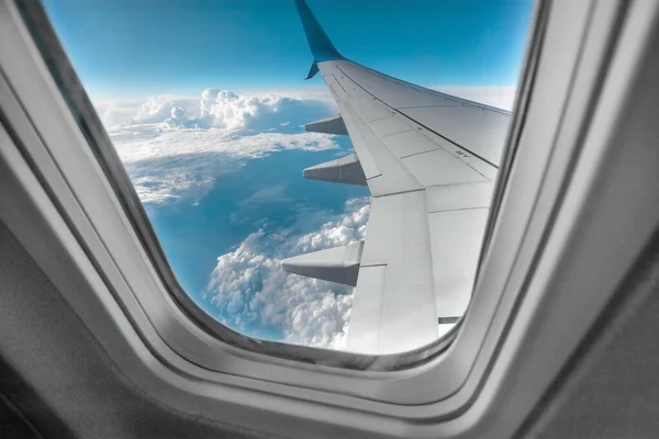 View from the window of a passenger plane above the clouds. International cargo transportation, air travel, transport, air travel, vacations. Copy space