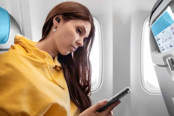 Flicka Med Smartphone Framför Ett Flygplansfönster Kabinen Ett Passagerarflygplan Använda — Stockfoto