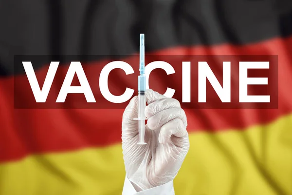 ドイツ国旗を背景に医師の手にワクチンが入った注射器 Covid 19コロナウイルス 免疫保護 Ncov感染症に対する治療2019 ワクチン接種 — ストック写真