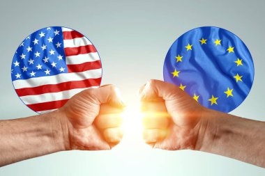 Erkek eller yumruklarını Amerika ve Avrupa 'nın bayraklarına karşı gösteriyor. Güç mücadelesi kavramı, çıkar çatışması, savaş, yaptırımlar, soğuk savaş, ekonomik mücadele