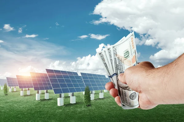 Χέρι Δολάρια Στο Φόντο Των Ηλιακών Συλλεκτών Επιχείρηση Ηλιακής Ενέργειας — Φωτογραφία Αρχείου