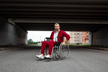 Engelli bir adam sokakta tekerlekli sandalyede oturuyor. Tekerlekli sandalye konsepti, engelli insan, hayat dolu, felçli, engelli insan, sağlık hizmetleri
