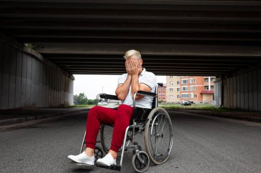 Tekerlekli sandalyede oturan bir adam, tek başına zorluklarla yüzleşir, depresyondadır. Tekerlekli sandalye konsepti, engelli insan, hayat dolu, felçli, engelli insan, sağlık hizmetleri