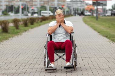 Tekerlekli sandalyede oturan bir adam, tek başına zorluklarla yüzleşir, depresyondadır. Tekerlekli sandalye konsepti, engelli insan, hayat dolu, felçli, engelli insan, sağlık hizmetleri