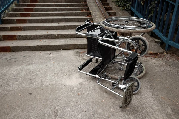 The concept of a wheelchair on the stairs turned over, disabled, full life, paralyzed. Problems for the disabled person