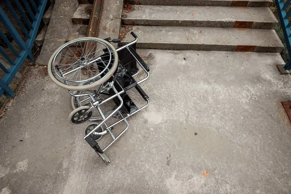 The concept of a wheelchair on the stairs turned over, disabled, full life, paralyzed. Problems for the disabled person