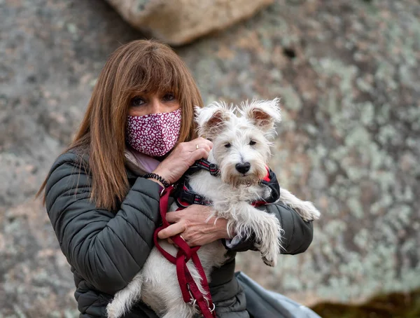 Adult Woman Face Mask Holding White Dog Defocused Stoned Background — ストック写真