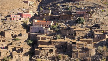 Fas 'ın Yüksek Atlas Dağları' ndaki uzak bir Berber köyünde, engebeli bir kayalık yamaçta sıkıca istiflenmiş antik taş ve çamur evleri ve uydu antenleri modern yaşamı gösteriyor..