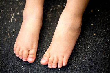 Çocuğun ayaklarına yakın siyah arkaplanda izole edilmiş ve kopyalama alanı.