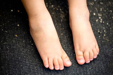 Çocuğun ayaklarına yakın siyah arkaplanda izole edilmiş ve kopyalama alanı.