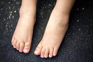 Çocuğun ayaklarına yakın siyah arkaplanda izole edilmiş ve kopyalama alanı.