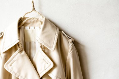 Beyazın üzerine izole edilmiş bej renkli bir trençkot..