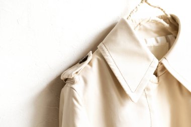 Beyazın üzerine izole edilmiş bej renkli bir trençkot..