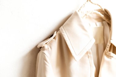 Beyazın üzerine izole edilmiş bej renkli bir trençkot..